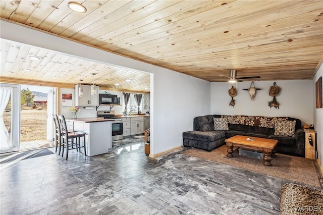 living room with wood ceiling, ceiling fan, and baseboards