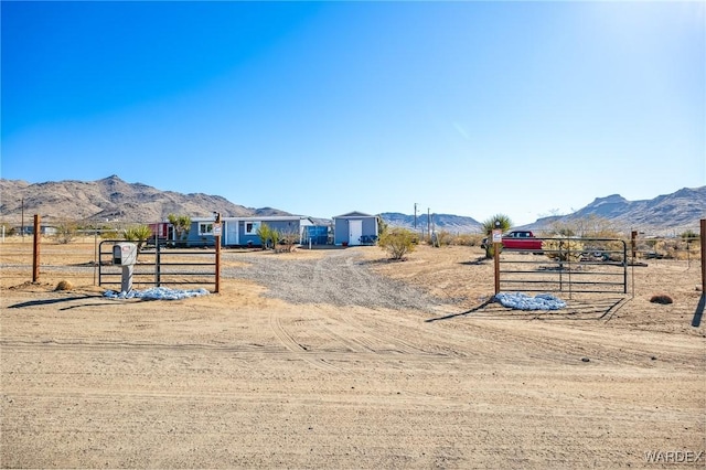 view of yard with a gate, fence, and a mountain view