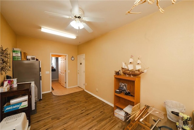 interior space with ceiling fan, baseboards, and wood finished floors