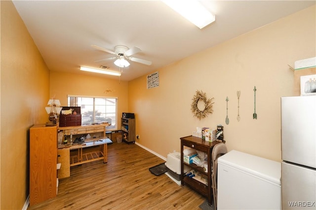 office space with baseboards, wood finished floors, visible vents, and a ceiling fan