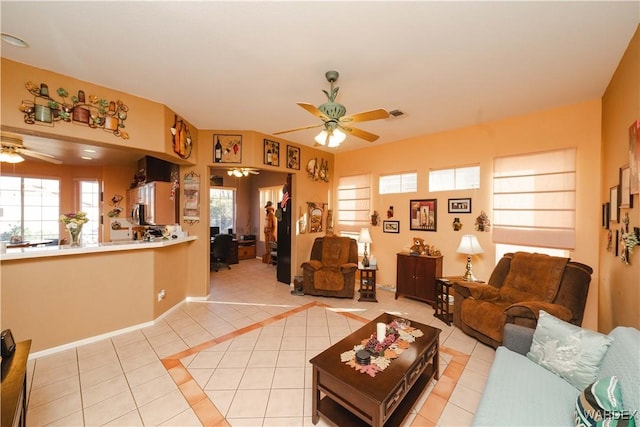 living area featuring light tile patterned floors, visible vents, and a ceiling fan