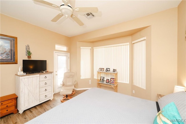 bedroom with a ceiling fan, visible vents, and light wood finished floors