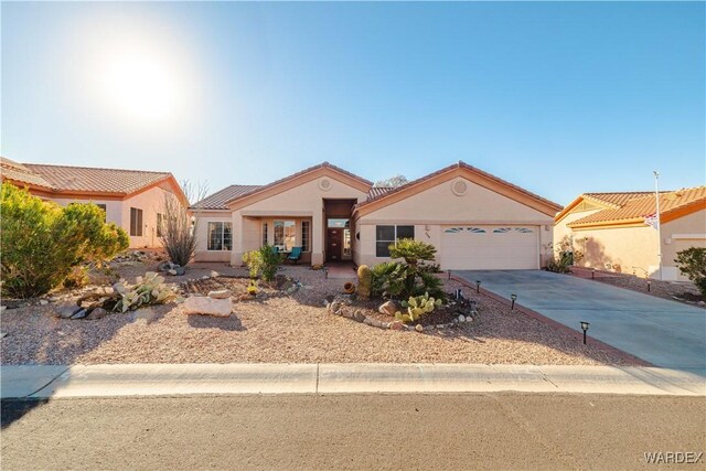 view of front of house with concrete driveway, an attached garage, and stucco siding