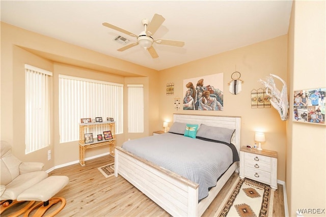 bedroom featuring visible vents, ceiling fan, light wood-style flooring, and baseboards