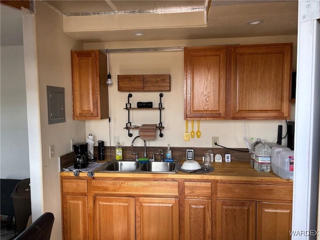 kitchen with brown cabinetry, electric panel, and a sink