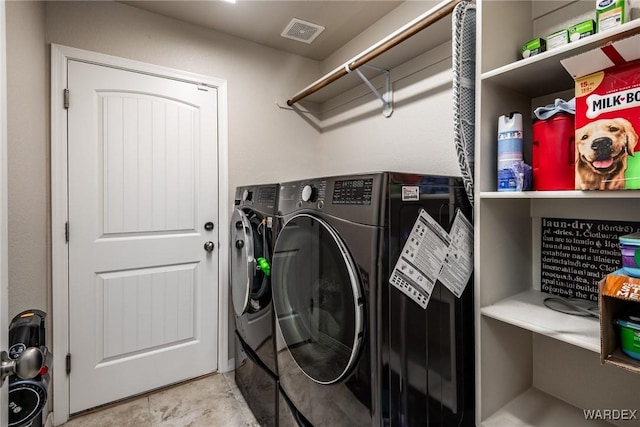 laundry area with laundry area, visible vents, and washer and clothes dryer