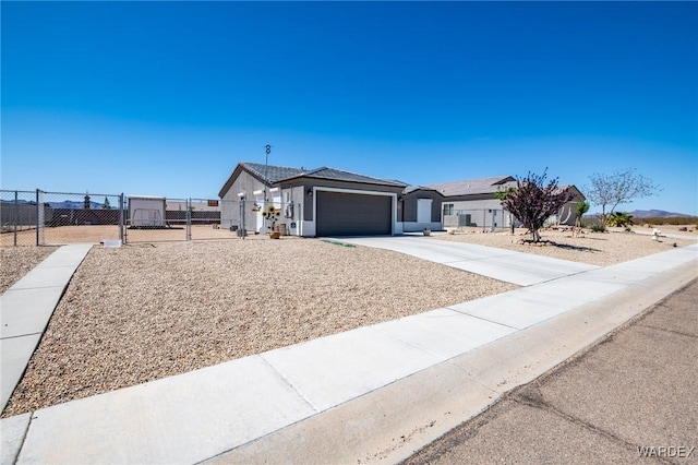 ranch-style home featuring a garage, concrete driveway, fence, stucco siding, and a gate