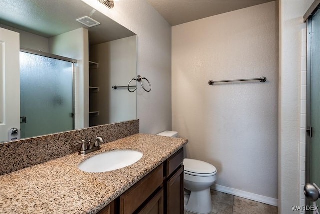 bathroom featuring vanity, baseboards, a stall shower, toilet, and visible vents