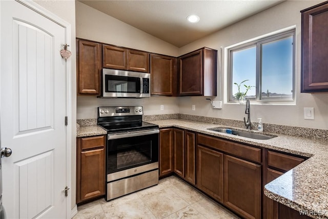 kitchen with vaulted ceiling, recessed lighting, dark brown cabinets, stainless steel appliances, and a sink