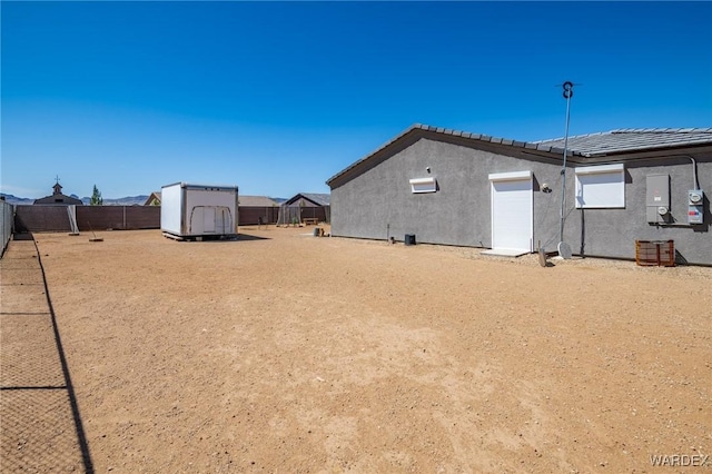view of yard featuring an attached garage, an outbuilding, a storage shed, and fence private yard