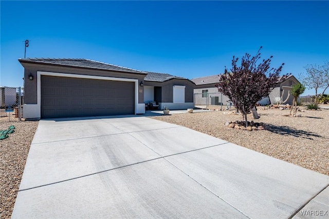 ranch-style home with concrete driveway, stucco siding, an attached garage, and a tile roof