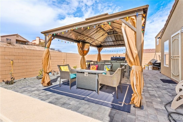 view of patio / terrace with a fenced backyard, outdoor dining area, and a gazebo