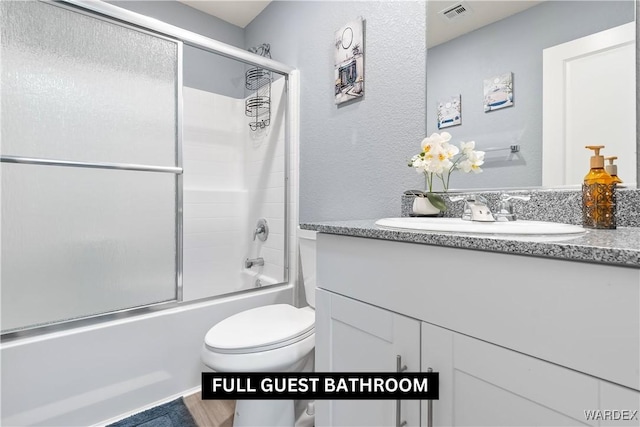 full bath featuring enclosed tub / shower combo, visible vents, vanity, and toilet