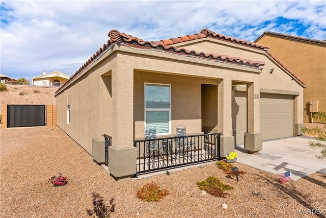 mediterranean / spanish-style home with a garage, a tiled roof, concrete driveway, and stucco siding