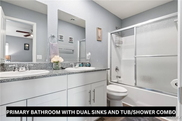 full bath with double vanity, shower / bath combination with glass door, visible vents, and a sink