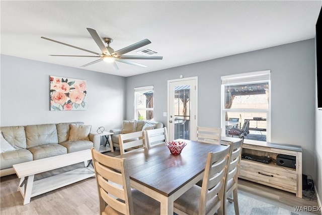 dining area with visible vents, ceiling fan, and wood finished floors