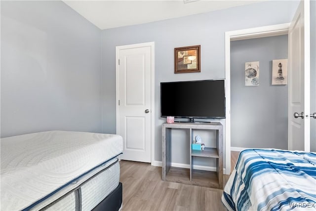 bedroom with light wood finished floors and baseboards