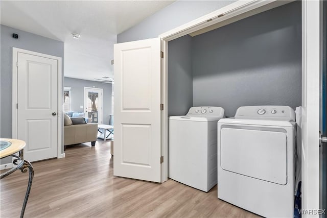 laundry area featuring laundry area, light wood finished floors, and washing machine and clothes dryer