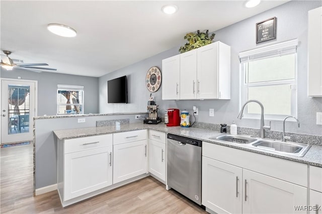 kitchen featuring white cabinets, a sink, light wood-type flooring, dishwasher, and a peninsula