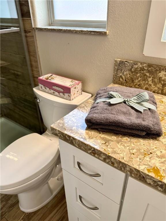 2023 E Sundance Dr, Fort Mohave, AZ 86426 - bathroom featuring toilet, vanity, wood finished floors, a tile shower, and a textured wall