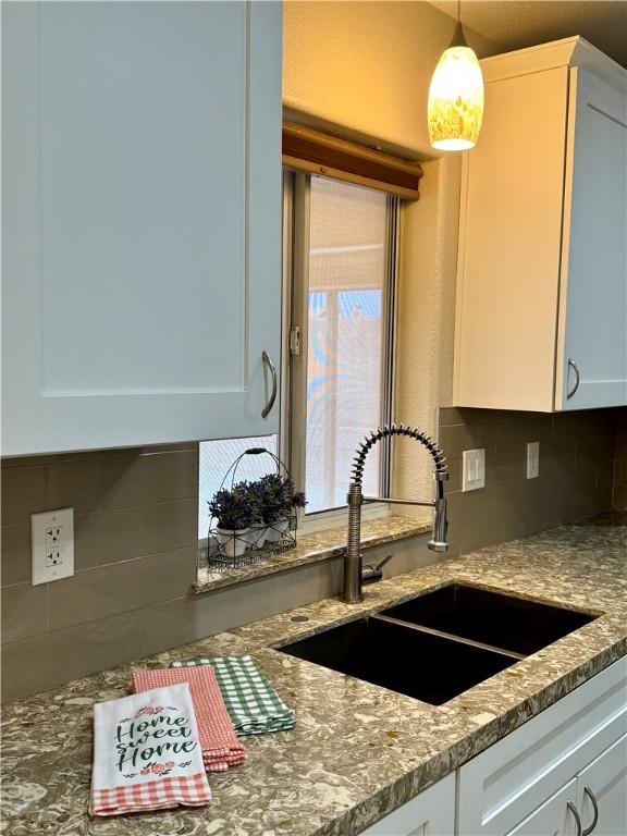 2023 E Sundance Dr, Fort Mohave, AZ 86426 - kitchen featuring a sink, backsplash, white cabinetry, and light stone counters