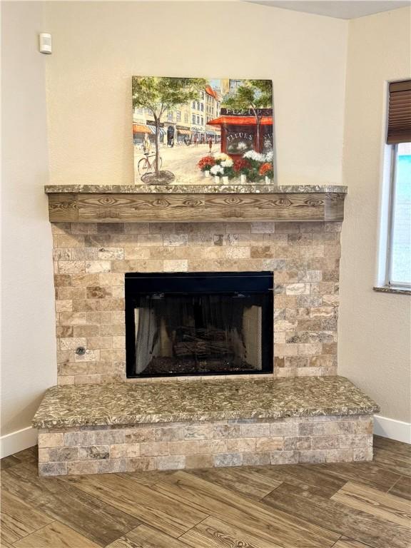 2023 E Sundance Dr, Fort Mohave, AZ 86426 - detailed view of baseboards, a fireplace with raised hearth, and wood finished floors