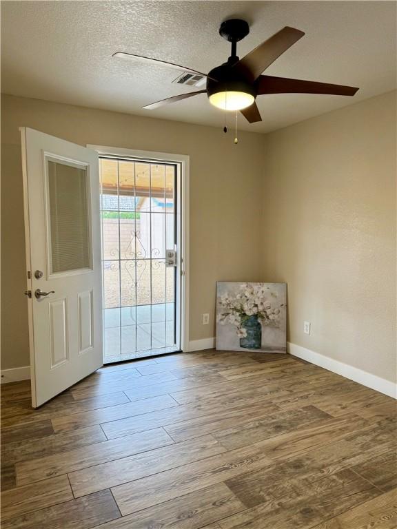2023 E Sundance Dr, Fort Mohave, AZ 86426 - unfurnished room featuring wood finished floors, a ceiling fan, baseboards, and a textured ceiling