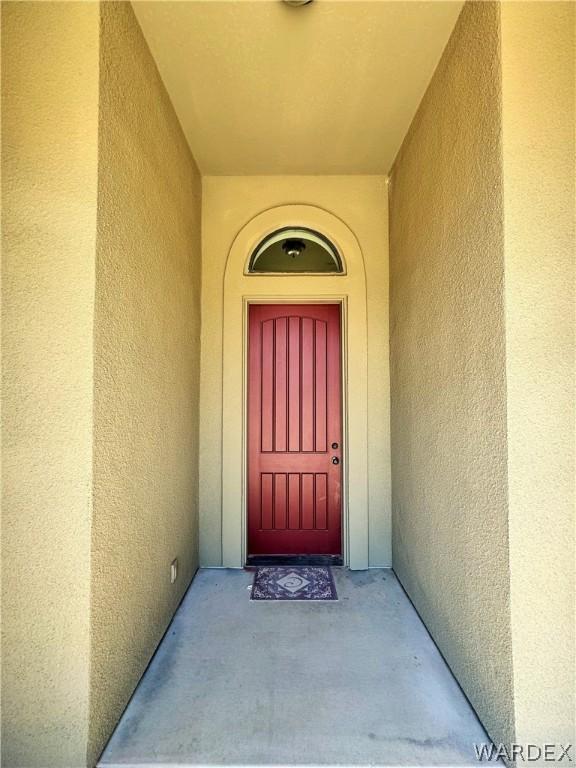 entryway featuring light tile patterned floors, baseboards, and arched walkways