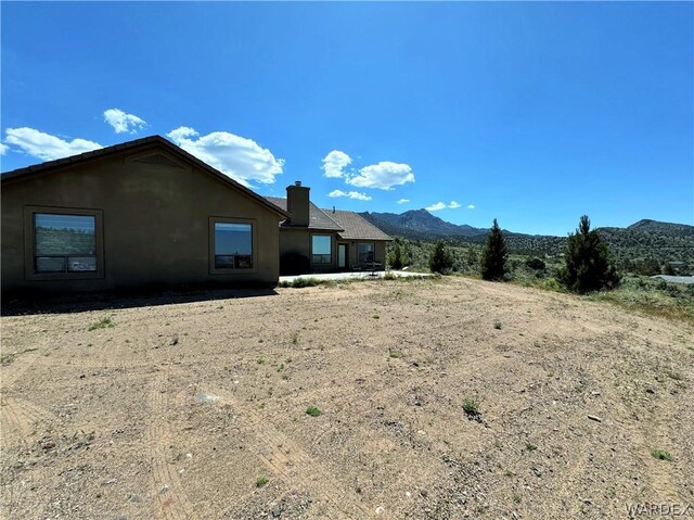 back of property featuring a chimney and a mountain view