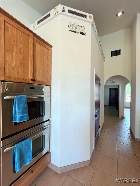 spare room featuring lofted ceiling, light wood-style flooring, baseboards, and a ceiling fan