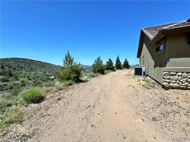 view of yard featuring central AC and a mountain view