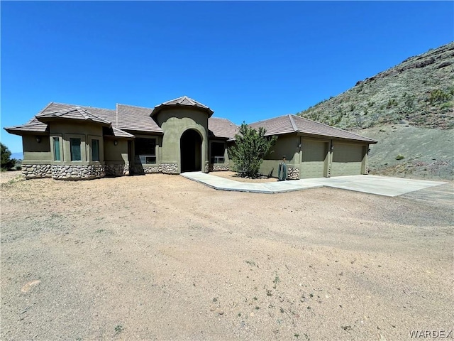 view of front of home featuring concrete driveway, an attached garage, a tile roof, and stucco siding