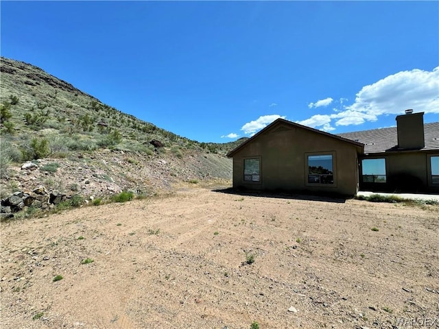 view of side of home with a chimney and a mountain view