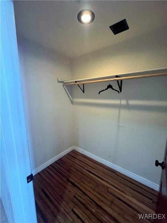 spacious closet with dark wood finished floors