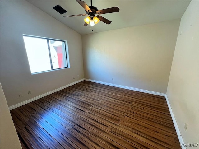 spare room featuring lofted ceiling, ceiling fan, baseboards, and dark wood finished floors