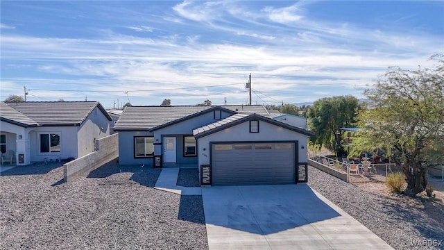 ranch-style house featuring concrete driveway, fence, an attached garage, and stucco siding