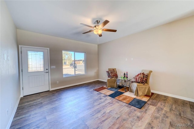 living area with ceiling fan, wood finished floors, and baseboards