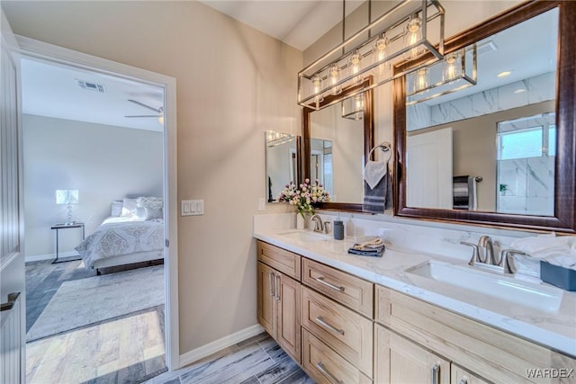 ensuite bathroom with ensuite bathroom, double vanity, a sink, and visible vents