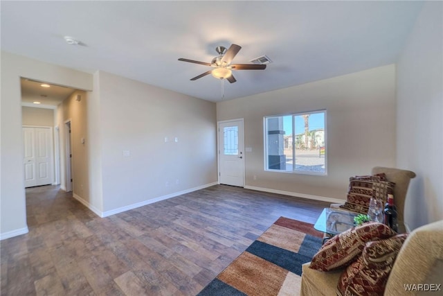 unfurnished room featuring baseboards, visible vents, ceiling fan, and wood finished floors