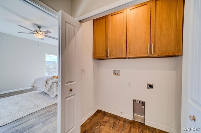 laundry area featuring hookup for a gas dryer, a ceiling fan, dark wood-style flooring, and cabinet space