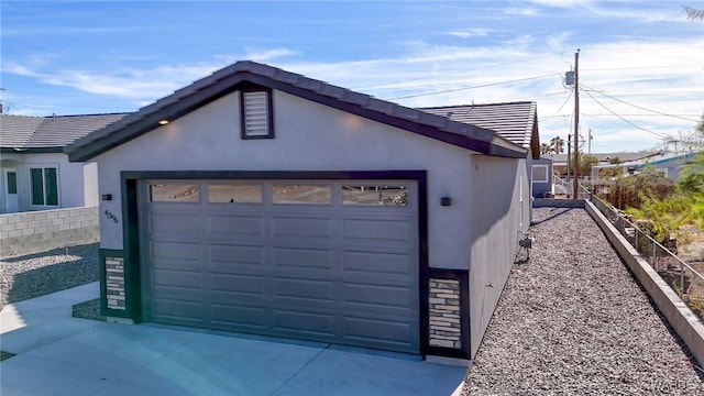 garage with driveway and fence