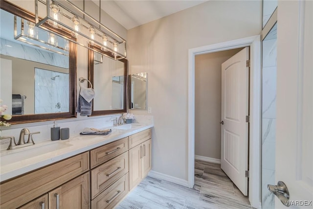 full bathroom featuring double vanity, baseboards, and a sink