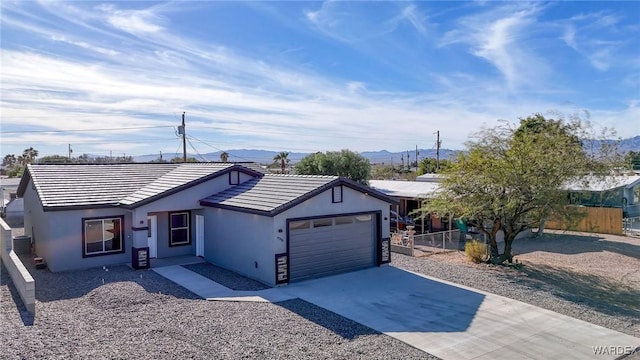 ranch-style house with stucco siding, concrete driveway, fence, a garage, and a tiled roof