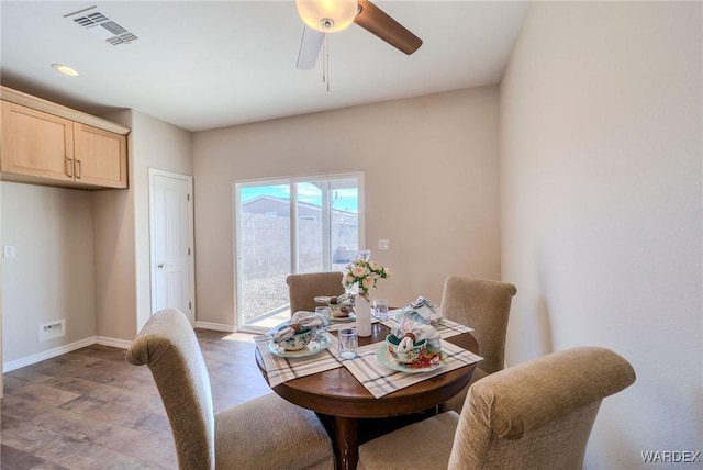 dining area with a ceiling fan, visible vents, baseboards, and wood finished floors