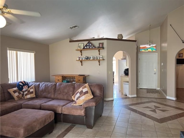 3454 Beale St, Bullhead City, AZ 86442 - living room featuring arched walkways, vaulted ceiling, ceiling fan, light tile patterned floors, and baseboards