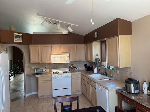 3454 Beale St, Bullhead City, AZ 86442 - kitchen featuring white appliances, a sink, lofted ceiling, decorative backsplash, and arched walkways
