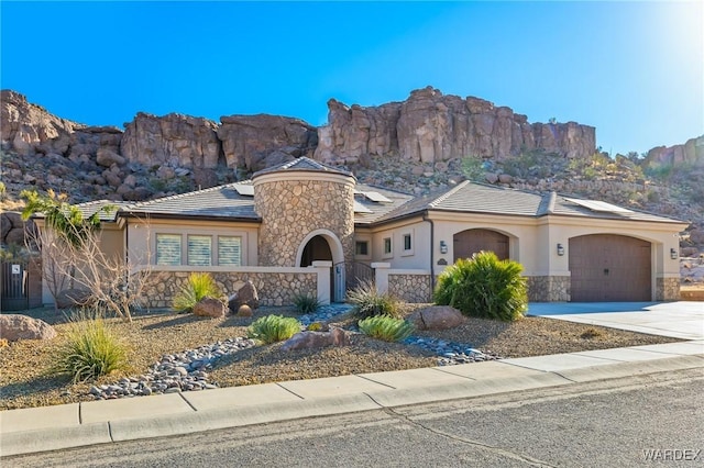 view of front of house featuring stone siding, concrete driveway, and stucco siding