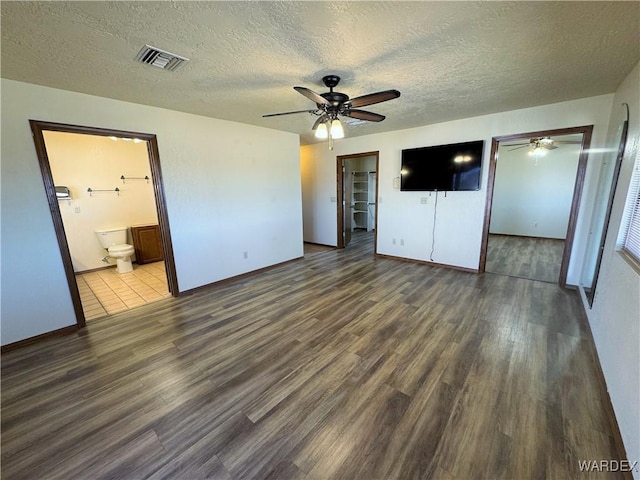 unfurnished bedroom with visible vents, a textured ceiling, and wood finished floors