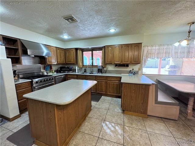 kitchen featuring brown cabinets, light countertops, high end stainless steel range oven, dishwasher, and wall chimney exhaust hood