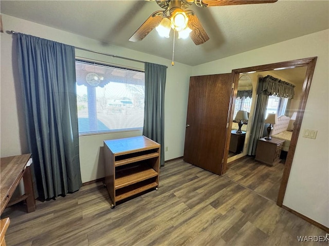 bedroom with ceiling fan, baseboards, and wood finished floors